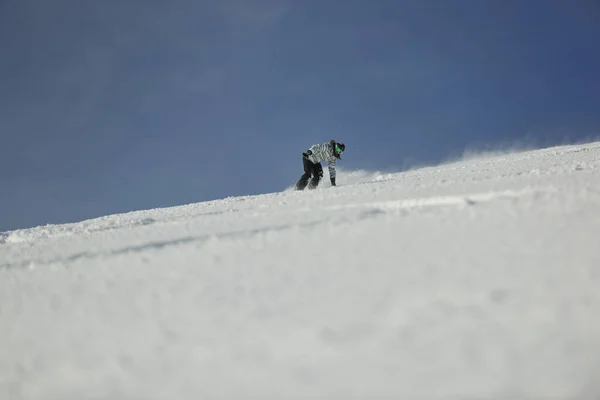 在冬季和阳光明媚的日子里 滑雪板上的女子在粉雪上飞奔下山 自由自在 — 图库照片