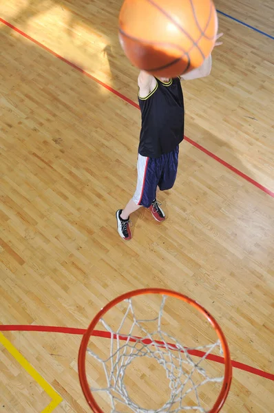 一名健康的年轻男子打篮球比赛在学校体育馆室内 — 图库照片