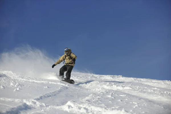 Freestyle Snowboarder Jump Ride Freestyle Bei Sonnigem Wintertag Berg lizenzfreie Stockfotos