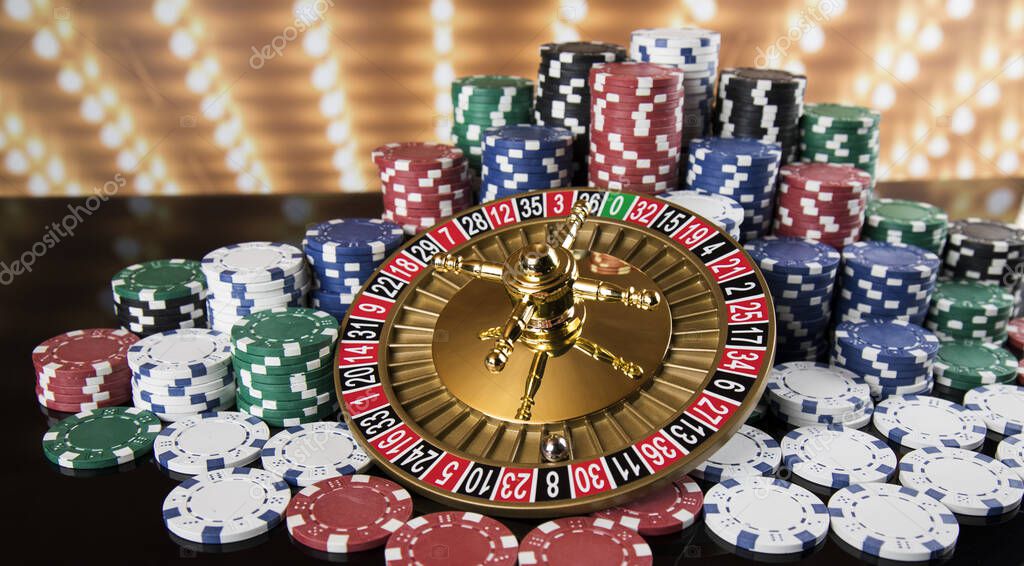 Poker Chips on gaming table, roulette wheel in motion, casino background