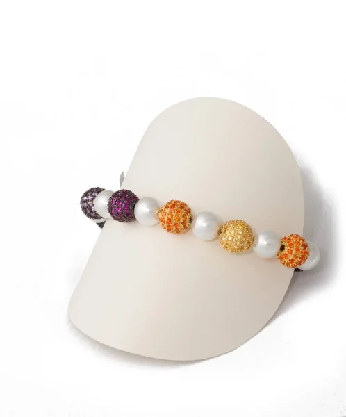 ディスプレイ上のマルチカラーボールと真珠のブレスレットスタンド — ストック写真