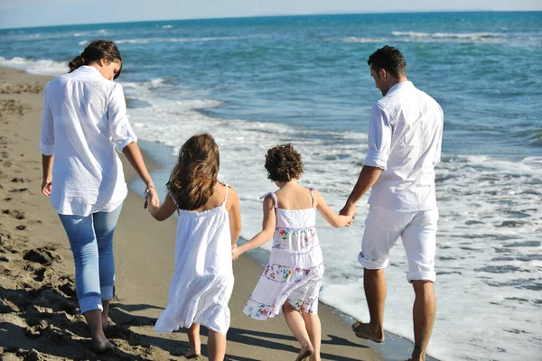 身穿白衣的快乐的年轻家庭 在美丽的海滩上与美丽的狗玩耍 — 图库照片