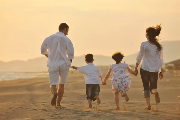 幸せな若い家族はビーチランを楽しんで日没にジャンプします — ストック写真