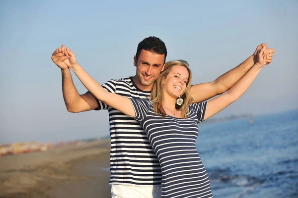 快乐的年轻夫妇在日落时在海滩上度过浪漫的时光 — 图库照片