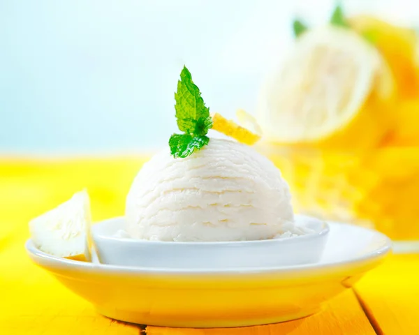 在一张黄色的木制桌子上 放了一勺新鲜柠檬糖蜜冰淇淋当甜点 — 图库照片