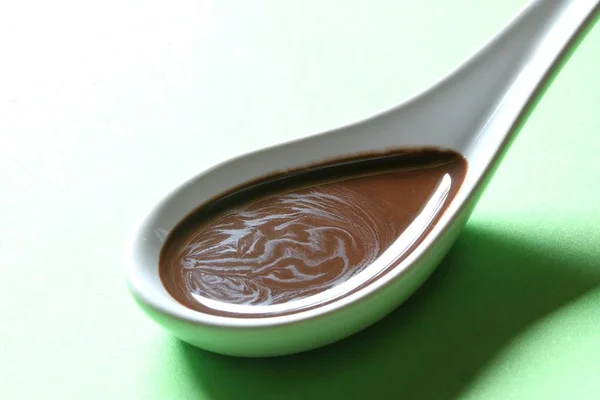 Schokoladensoße Auf Einem Porzellanlöffel — Stockfoto