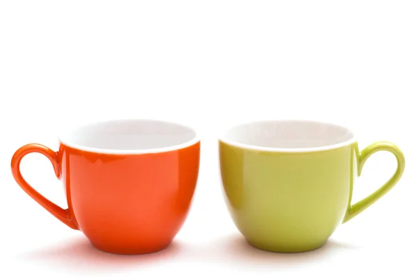 白色背景的橙色和绿色杯子 — 图库照片