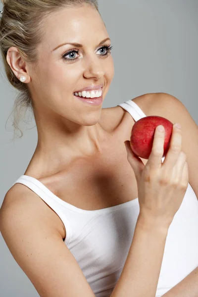 Vacker Ung Kvinna Äter Ett Äpple Klädd Vit Väst Topp — Stockfoto