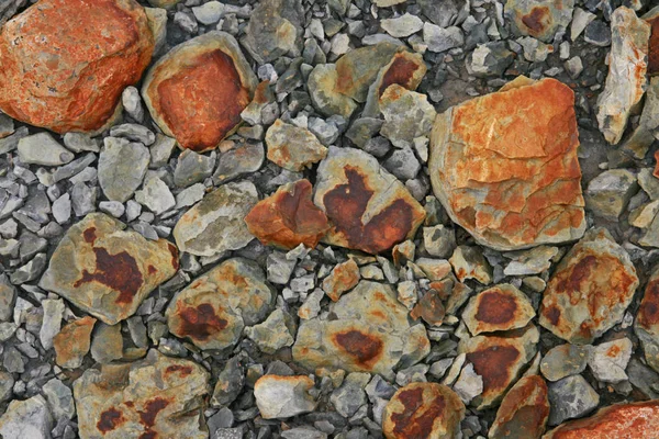 stones with orange coating in geothermal krysuvik - iceland
