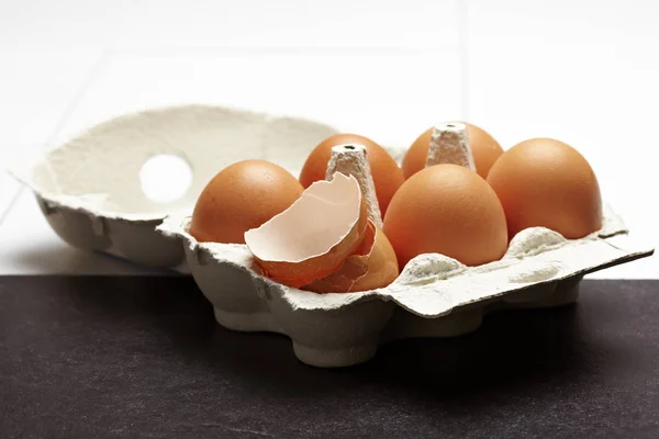 Egg box carton with one cracked egg