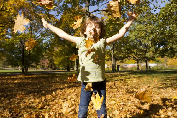그녀는 가을에 나뭇잎을 던져서 — 스톡 사진