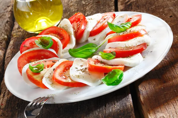 Kolorowe Plasterki Sera Pomidora Ułożone Naprzemiennie Talerzu Ozdobione Ziołami Podawanymi — Zdjęcie stockowe