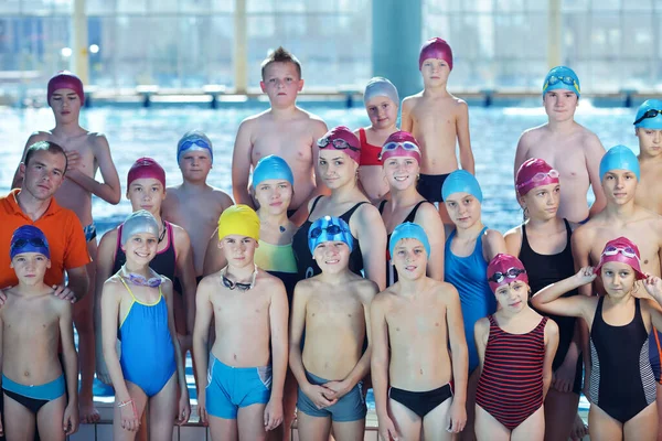 泳ぐことを学ぶスイミング プール クラスで幸せな子供の子供のグループ — ストック写真