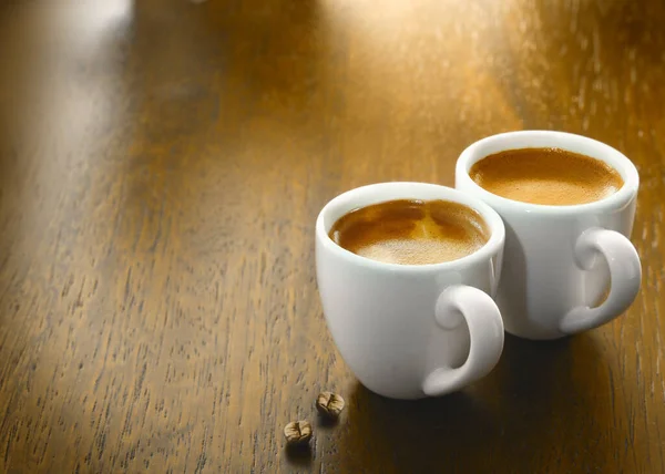 Zwei Tassen Frisch Gebrühten Espressokaffee Mit Zwei Einzelnen Kaffeebohnen Auf — Stockfoto