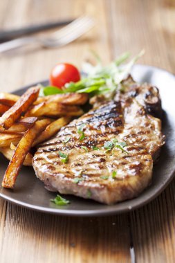 juicy grilled pork chop (neck cut) with greens clipart