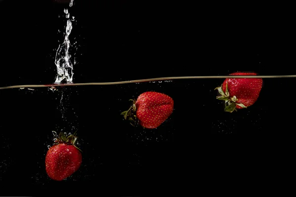 Frische Erdbeeren Werden Auf Schwarzem Hintergrund Ins Wasser Geworfen — Stockfoto