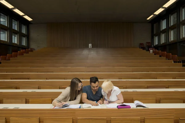 a student and two female students learn together in the lecture hall