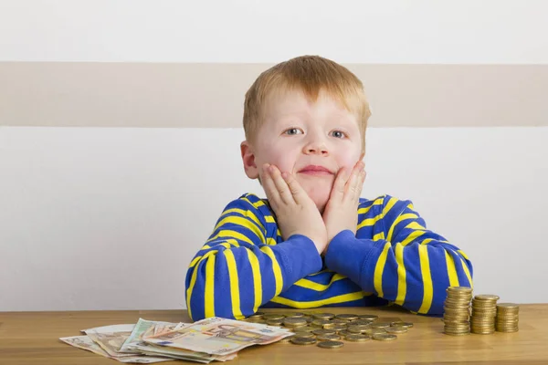 Junge Sitzt Staunend Vor Geldtürmen Und Geldscheinen — Stockfoto