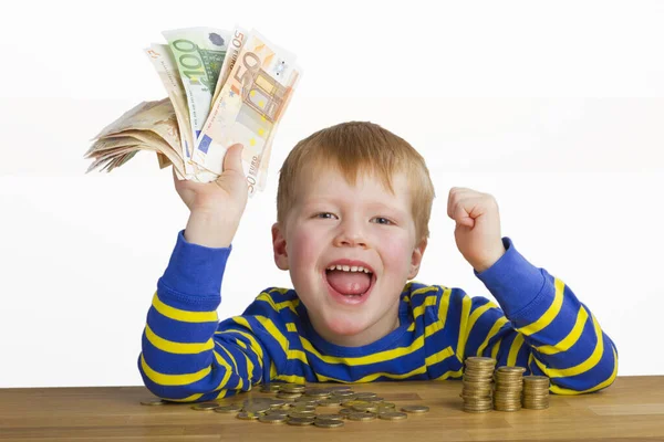 Jubelnder Junge Mit Geldscheinen Der Hand Der Vor Münzen Sitzt — Stockfoto