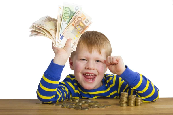 Jubilant Chłopiec Banknotami Ręku Siedzi Przed Monetami — Zdjęcie stockowe