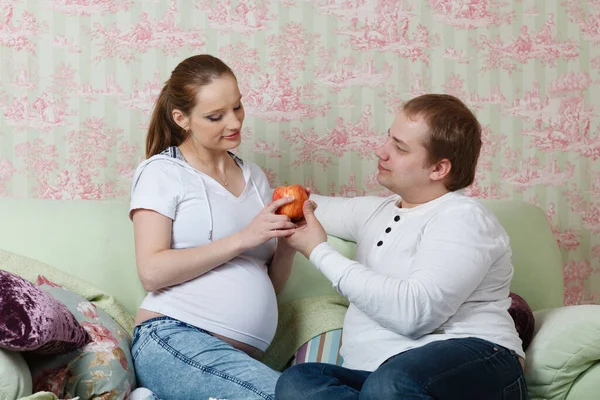 Feliz Familia Embarazada Con Frutas Sentarse Sofá Casa —  Fotos de Stock