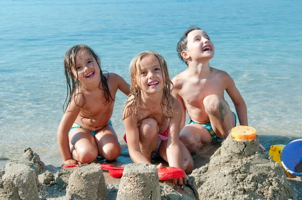 Tres Niños Que Hacen Castillo Junto Mar — Foto de Stock