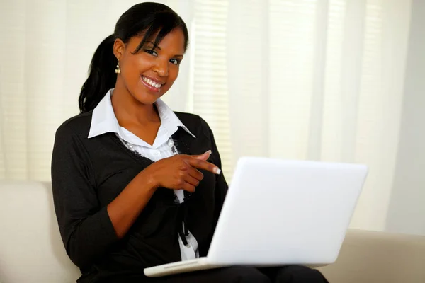 Портрет Жінки Чорному Костюмі Вказує Екран Ноутбука Сидячи Дивані Вдома — стокове фото