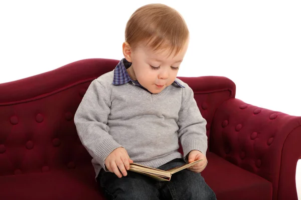 Küçük Bir Çocuk Çocuk Kanepesinde Oturuyor Kitap Okumakla Ilgileniyor Gibi — Stok fotoğraf