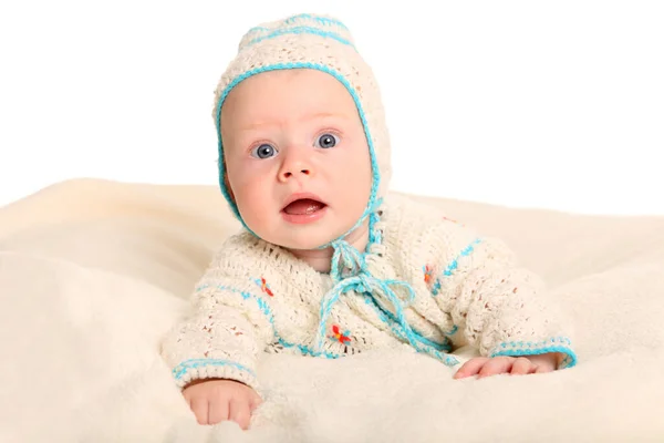 a baby holds his head and apparently makes a little game of hide with the camera.