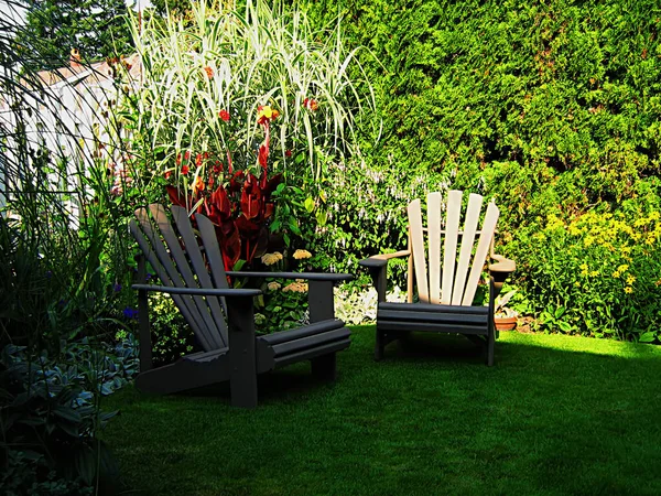 庭にある一対の木製の芝生の椅子の写真 — ストック写真