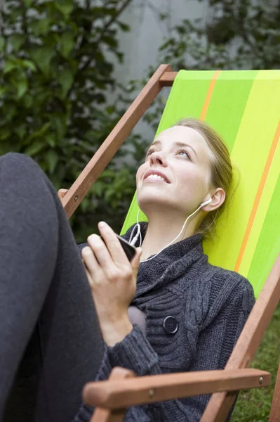 Mujer Joven Escuchando Música Mientras Relaja Con Comodidad Una Tumbona — Foto de Stock