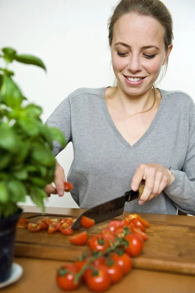 Jovem Mulher Balcão Cozinha Cortando Tomates Frescos Com Uma Faca — Fotografia de Stock