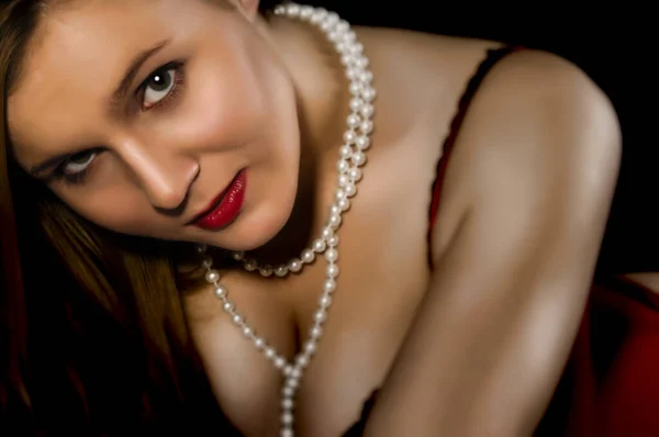 魅力的な若い女性です赤い下着のロールでソファ — ストック写真