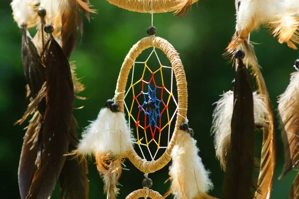 用羽毛线和珠子绳挂在树枝上的捕猎者 — 图库照片