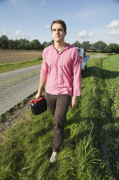 Mladý Muž Běží Jerrycans Odlehlé Venkovské Silnici Podél Směrem Kameře — Stock fotografie