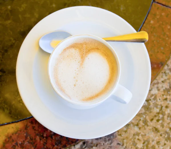 屋外カフェの石のテーブルの上にカプチーノのカップ — ストック写真