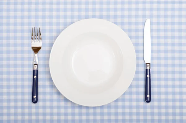 青い白いテーブルクロスのフォークとナイフテーブルで — ストック写真
