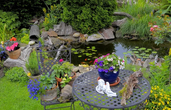 ornamental garden,garden pond with goldfish,garden table and chairs