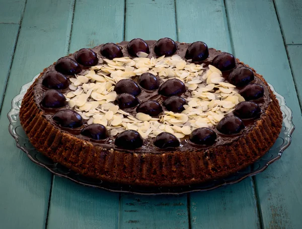 Torta Ciliegie Mandorle Cioccolato Piatto Vetro Tavolo Turchese — Foto Stock