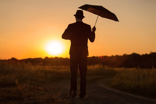 Ένας Νεαρός Άνδρας Περπατά Μια Ομπρέλα Στο Ηλιοβασίλεμα — Φωτογραφία Αρχείου