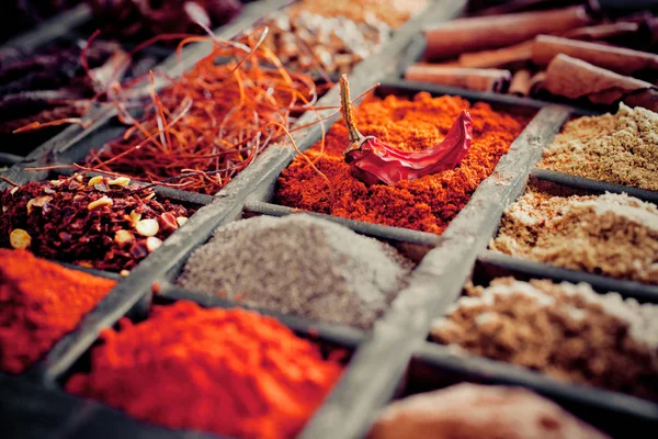 Close-up of different types of Assorted Spices in a wooden box.