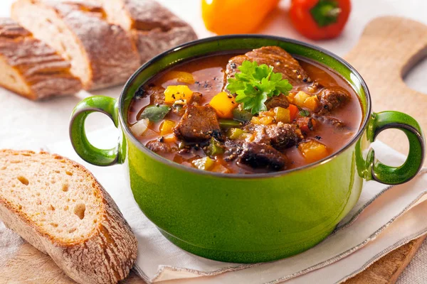Delicious goulash casserole in a metal pot with thick rich gravy, meat and vegetables for a wholesome meal