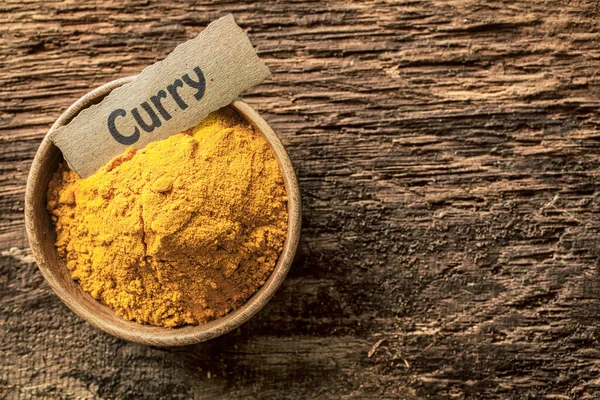 Bowl of curry powder, a traditional blend of masala, turmeric and Asian spices for use as a hot savoury cooking ingredient