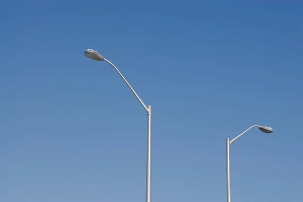 Två Höga Gatlyktor Mot Klarblå Himmel — Stockfoto