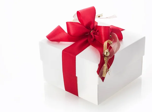 为庆祝圣诞节 情人节 生日或结婚周年 白色礼品盒上系着漂亮的红丝带和饰有豪华金条的蝴蝶结 可以近距离观赏白色的风景 — 图库照片