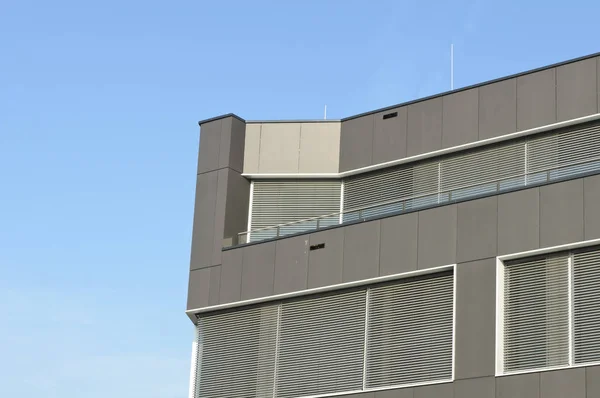 Mavi Gökyüzünün Önündeki Gri Metal Panelli Alüminyum Panjurlu Bir Binasının — Stok fotoğraf