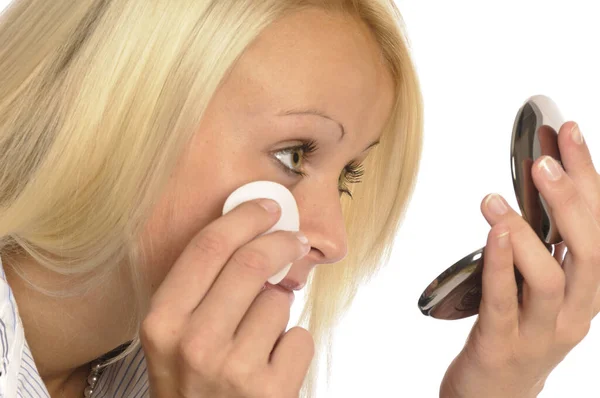 stock image young blond woman is making beautiful,make-up in front of white background