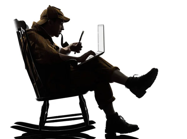 夏洛克 福尔摩斯与计算机笔记本电脑剪影坐在摇椅上在白色背景上的工作室 — 图库照片