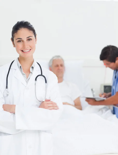 Ärztin Mit Stethoskop Lächelt Während Sie Vor Einem Praktikanten Und — Stockfoto