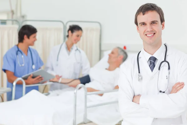 Усміхнений Лікар Перетинає Руки Коли Він Стоїть Перед Пацієнтом Який — стокове фото